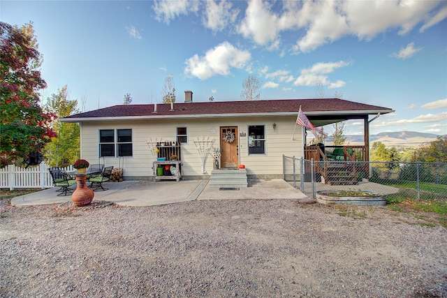 back of property featuring a mountain view and a patio area