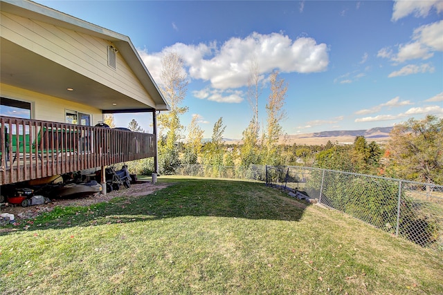 view of yard featuring a deck with mountain view