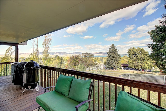 wooden deck with a lawn, area for grilling, and a mountain view