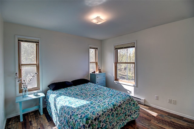 bedroom featuring a baseboard radiator, dark wood-type flooring, and multiple windows