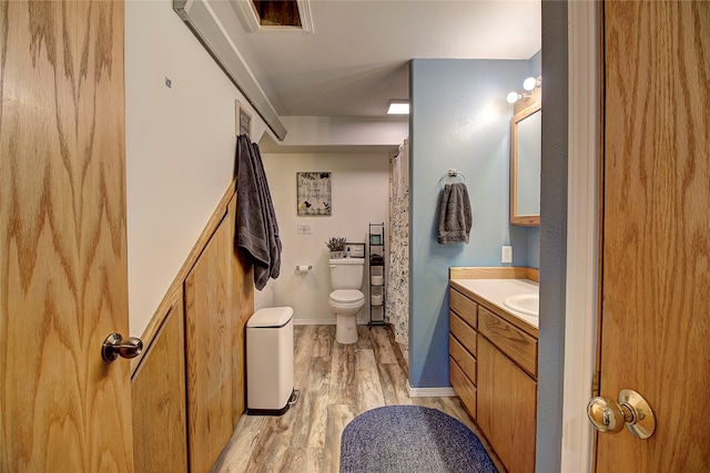 bathroom with wood-type flooring, vanity, and toilet