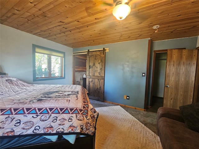 bedroom with wood ceiling, a closet, carpet floors, a barn door, and ceiling fan