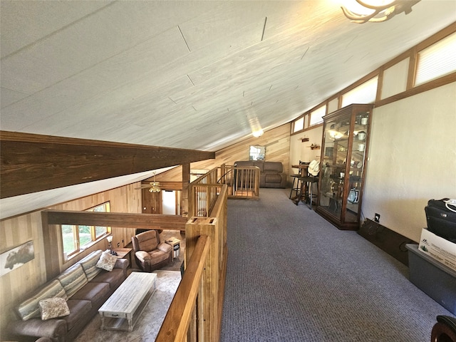 interior space featuring wood walls, vaulted ceiling, and ceiling fan