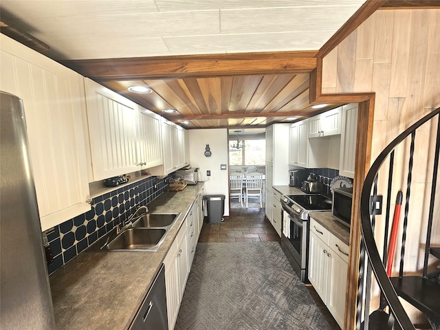 kitchen with backsplash, stainless steel appliances, white cabinetry, and sink