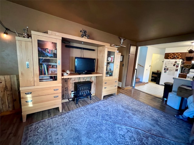 living room with a wood stove and dark hardwood / wood-style flooring