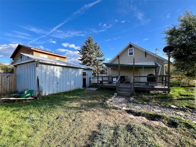 rear view of house with a lawn and a deck