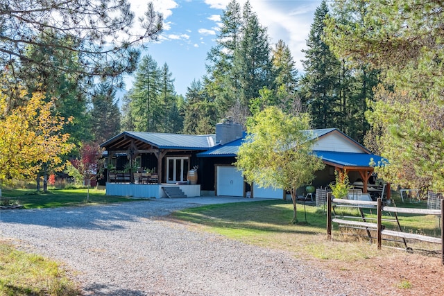 view of front of house featuring a front yard, a garage, and covered porch