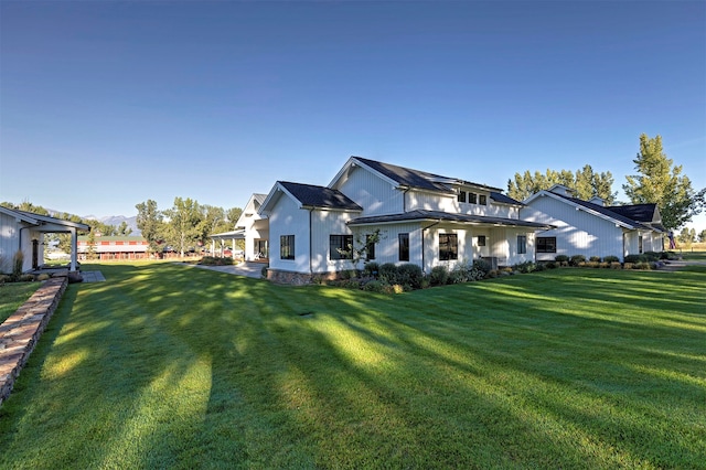 rear view of property featuring a lawn