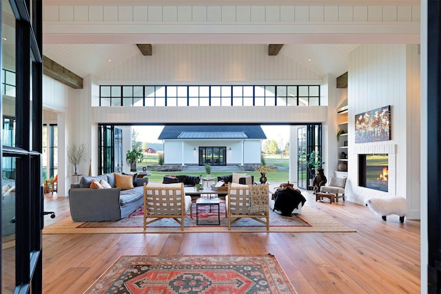 living room with high vaulted ceiling, beamed ceiling, and hardwood / wood-style floors