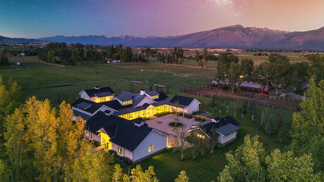 aerial view at dusk with a mountain view and a rural view