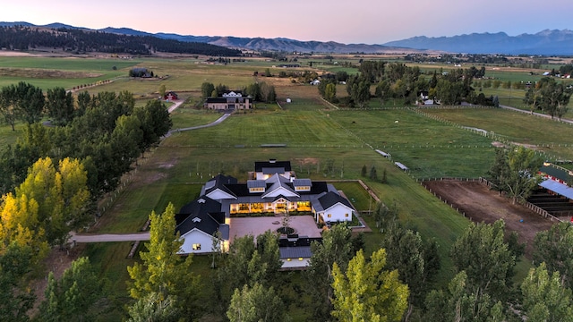 aerial view at dusk with a mountain view and a rural view