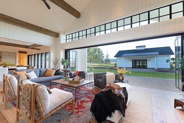 living room featuring ceiling fan, hardwood / wood-style floors, beam ceiling, and high vaulted ceiling