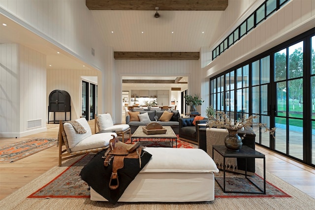 living room featuring hardwood / wood-style flooring, beam ceiling, and high vaulted ceiling