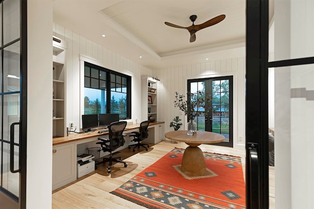 office space featuring light wood-type flooring, built in desk, a raised ceiling, and french doors