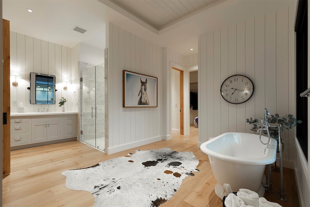 bathroom with independent shower and bath, vanity, wooden walls, and hardwood / wood-style floors