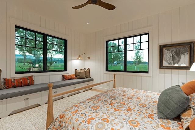 bedroom with wooden walls and ceiling fan