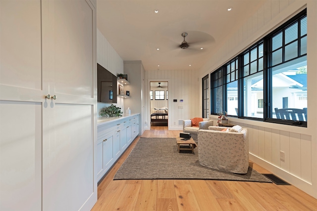 living room with light wood-type flooring and ceiling fan