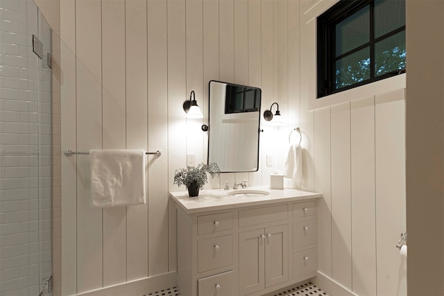 bathroom featuring a tile shower, tile patterned floors, wood walls, and vanity