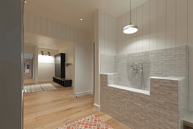 bathroom featuring wood walls and hardwood / wood-style flooring