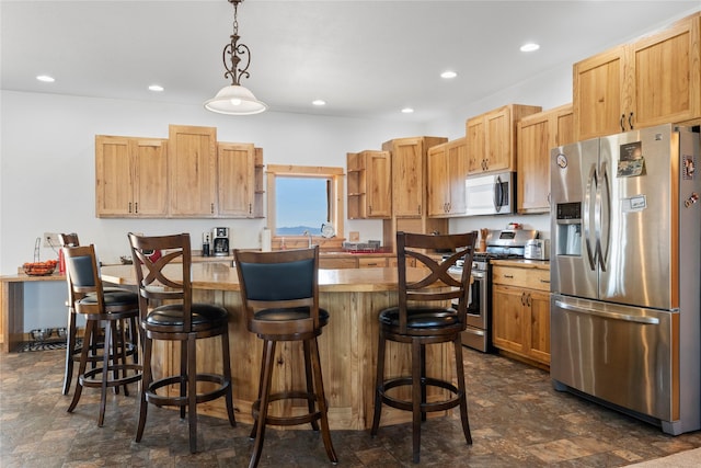 53 Skyview Ln, Townsend, MT 59644 - kitchen with appliances with stainless steel finishes, stone finish floors, pendant lighting, a kitchen island, and a breakfast bar