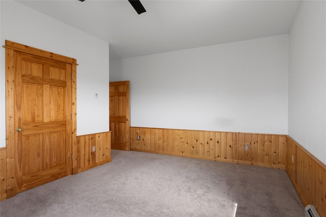 53 Skyview Ln, Townsend, MT 59644 - carpeted spare room featuring a baseboard radiator, a wainscoted wall, wood walls, and ceiling fan
