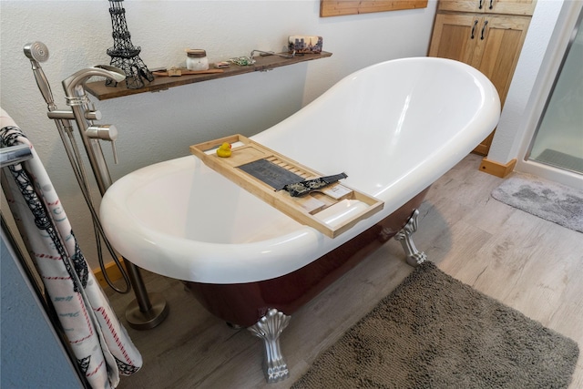 53 Skyview Ln, Townsend, MT 59644 - full bath featuring wood finished floors, a freestanding bath, and a textured wall