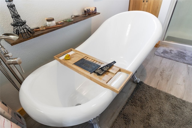 53 Skyview Ln, Townsend, MT 59644 - full bath featuring a freestanding bath, wood finished floors, and a textured wall