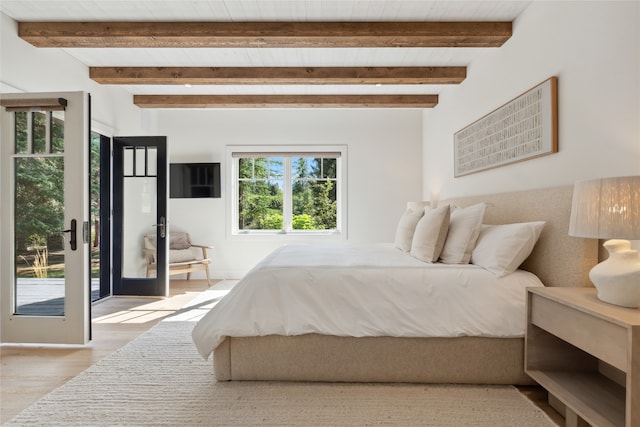 bedroom featuring light hardwood / wood-style floors and beamed ceiling