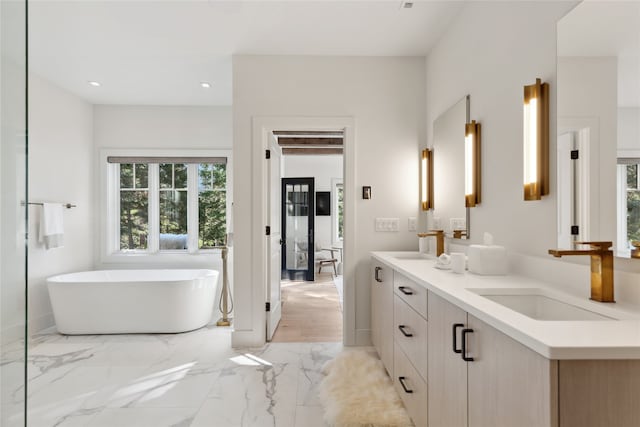 bathroom featuring wood-type flooring, vanity, and a tub to relax in