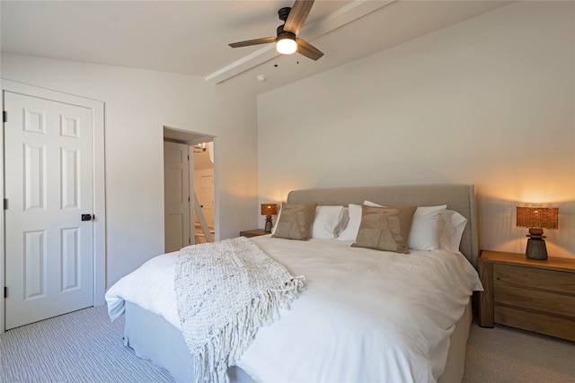 bedroom with light colored carpet, vaulted ceiling, ensuite bathroom, and ceiling fan