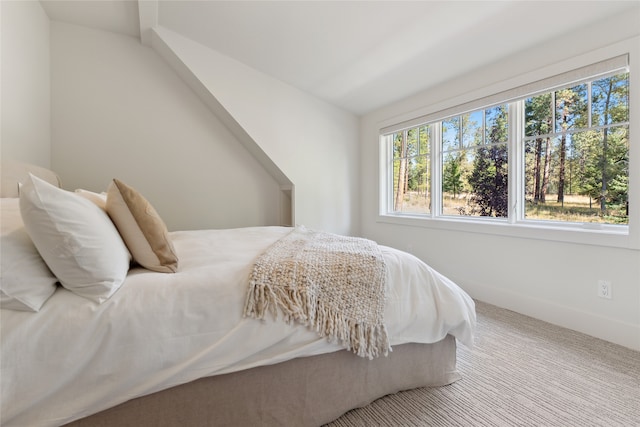 carpeted bedroom with lofted ceiling