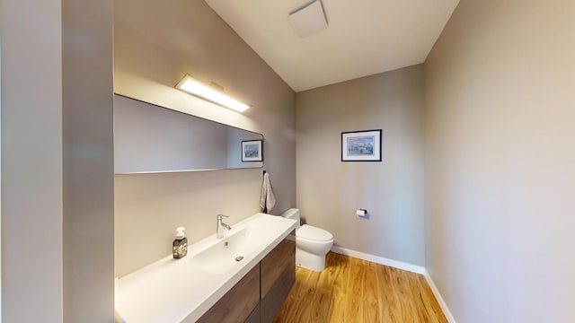 bathroom featuring vanity, toilet, and hardwood / wood-style flooring