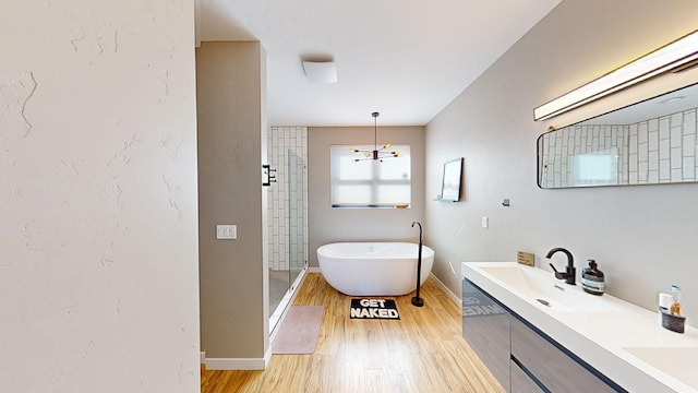 bathroom with vanity, hardwood / wood-style flooring, and plus walk in shower