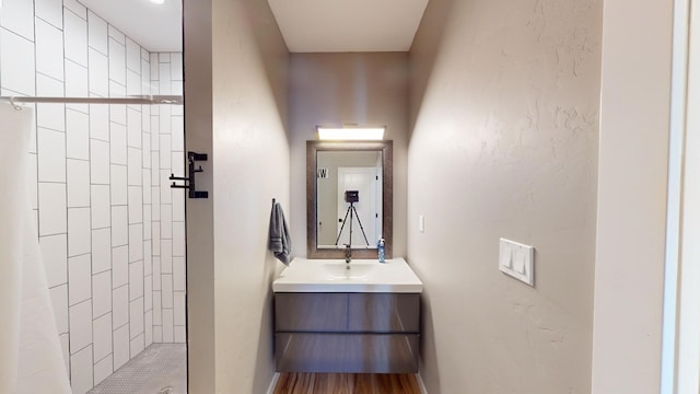 bathroom featuring walk in shower and vanity