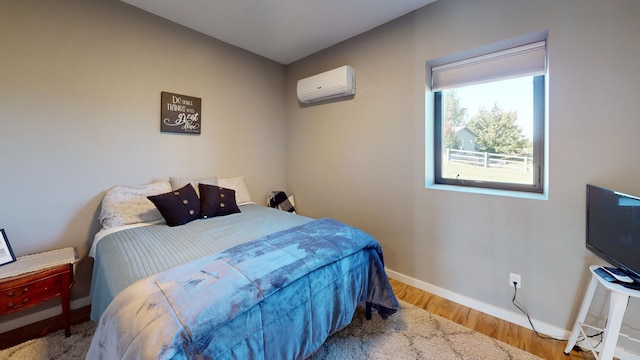 bedroom featuring an AC wall unit and hardwood / wood-style floors