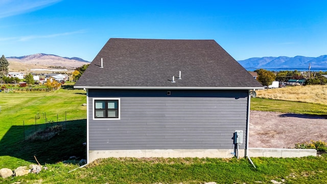 view of side of home featuring a lawn and a mountain view