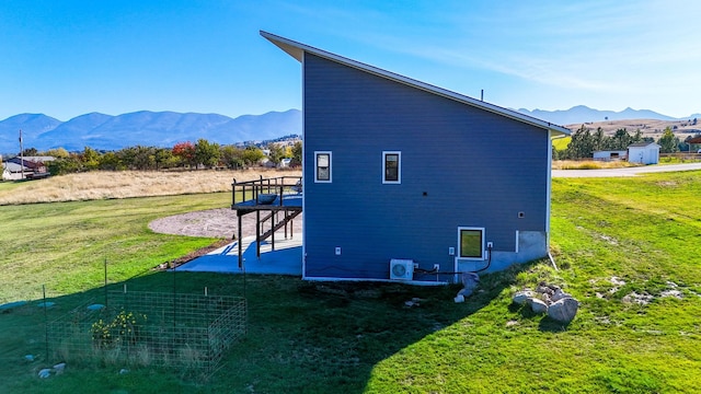 view of home's exterior with a mountain view, a yard, and a patio area