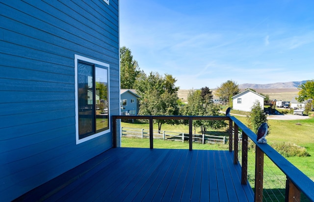 wooden terrace featuring a yard and a mountain view