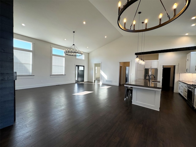 kitchen featuring pendant lighting, an island with sink, dark hardwood / wood-style floors, and white cabinetry