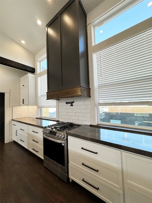 kitchen featuring white cabinets, dark stone counters, high end stainless steel range oven, premium range hood, and dark hardwood / wood-style floors