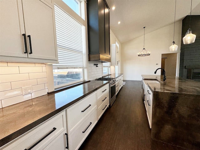 kitchen featuring dark hardwood / wood-style floors, tasteful backsplash, white cabinetry, hanging light fixtures, and stainless steel range