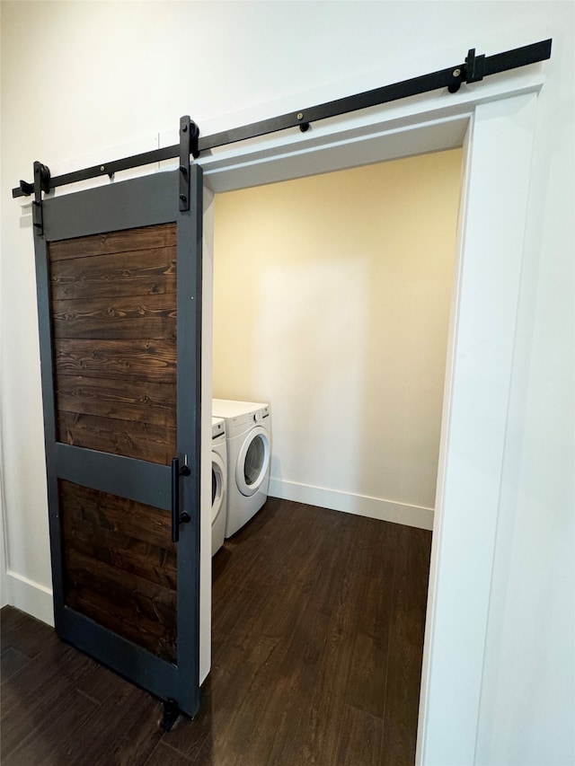 washroom featuring washer and clothes dryer, dark hardwood / wood-style floors, and a barn door