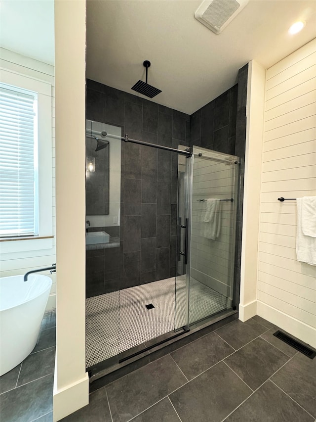 bathroom with independent shower and bath, tile patterned flooring, and wood walls