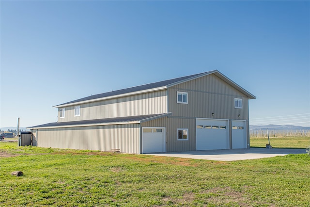 rear view of house featuring a garage and a yard