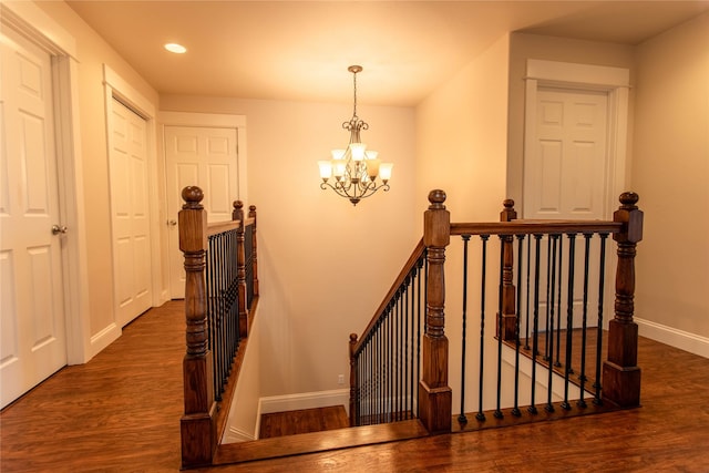staircase with a chandelier, recessed lighting, baseboards, and wood finished floors