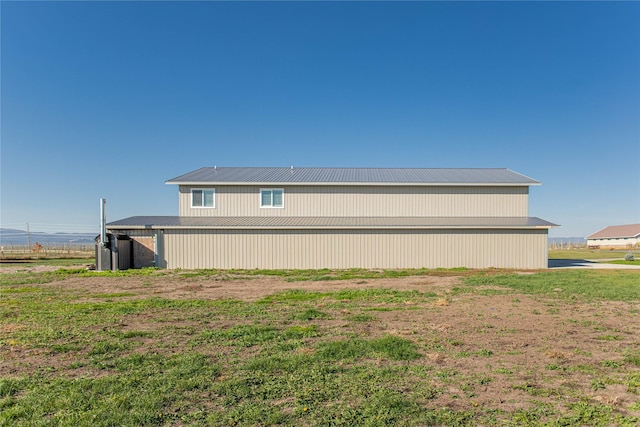 view of property exterior featuring an outbuilding and metal roof