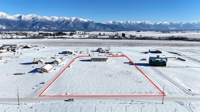 snowy aerial view featuring a mountain view