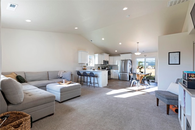 carpeted living room with vaulted ceiling