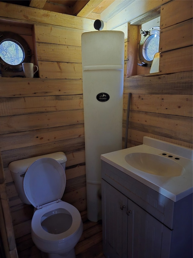 bathroom featuring wood ceiling, vanity, wooden walls, beam ceiling, and toilet