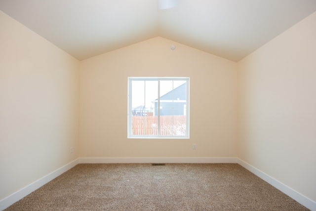 unfurnished room with vaulted ceiling and carpet